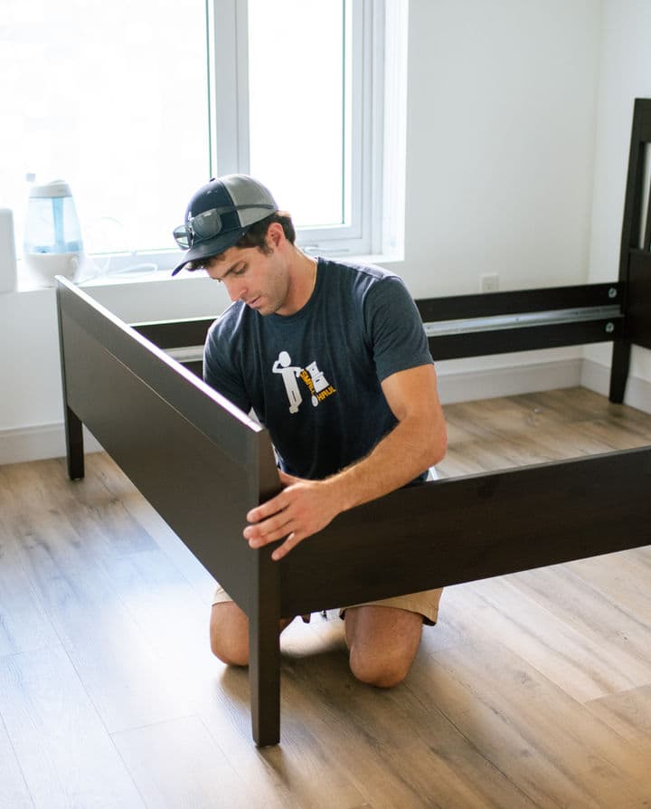 Small Haul team member breaking down a bed frame for disposal