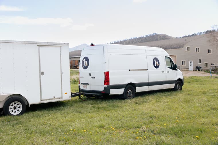 A Small Haul van parked in an open Colorado field with mountains behind